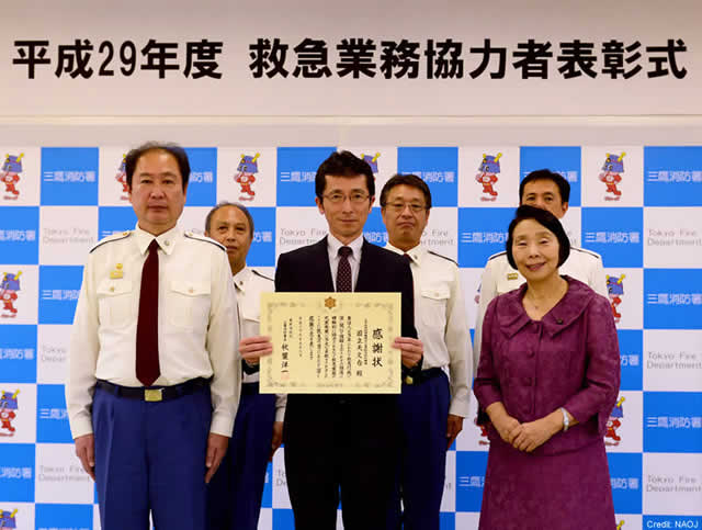 感謝状を手にした国立天文台の高橋施設課長を中心とした集合写真