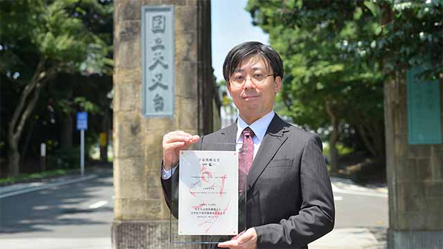 採択認定証を手にする阿久津助教