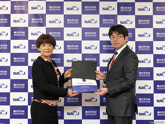 Ms. Asako Watanabe (left) presenting the certificate to Dr. Masami Ouchi (right).